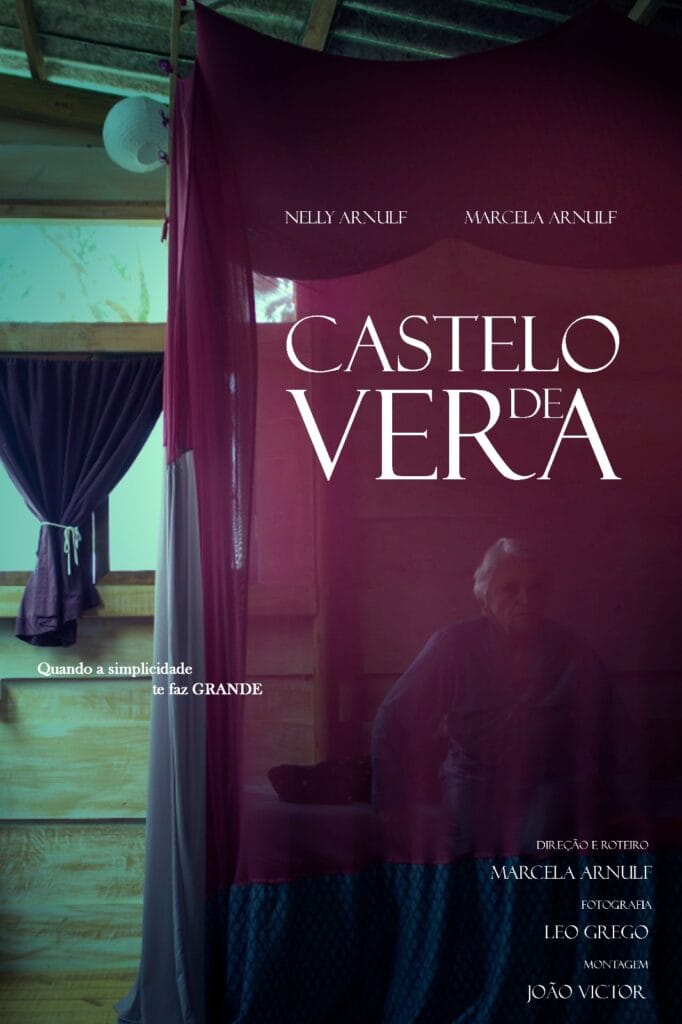 A imagem é um cartaz do filme “Castelo de Vera”. No centro, há um tecido translúcido de cor avermelhada, pendurado, que divide o espaço e cobre parcialmente uma pessoa sentada ao fundo, cuja expressão é difícil de distinguir devido à baixa iluminação. O cenário é um ambiente interno, com janelas de madeira, cortinas escuras e uma luz suave entrando pelas aberturas. O título do filme, "Castelo de Vera", está escrito em letras grandes e brancas, com destaque no centro. Acima do título, aparecem os nomes "Nelly Arnulf" e "Marcella Arnulf." Abaixo do título, lê-se o texto: "Quando a simplicidade se faz GRANDE." Os créditos técnicos, como direção, fotografia e montagem, estão listados na parte inferior do cartaz, incluindo o nome de Marcella Arnulf como diretora. O design transmite uma atmosfera intimista e poética.