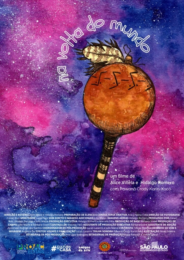 A imagem apresenta o cartaz do filme “Na Volta do Mundo" com as letras em branco. Ao fundo há uma pintura à tinta da galáxia, em tons de azul escuro, roxo, rosa e estrelas brancas. No meio da imagem há um chocalho indígena marrom com detalhes em amarelo claro e uma pena na ponta, também pintado com tinta. Ao lado do chocalho há o texto “um filme de Alice Villela e Hidalgo Romero com Powanã Crody Kariri-Xocó”. Na parte debaixo da imagem, em letras pequenas, temos os nomes da equipe de produção, seguidos da logo dos apoiadores e patrocinadores.